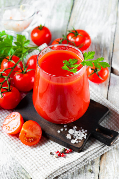  Glass of fresh tomato juice close up on the table, vertical photo. High quality photo - Valokuva, kuva