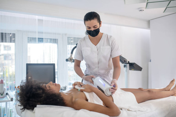 Young girl and doctor during cosmetic procedure - Foto, Bild