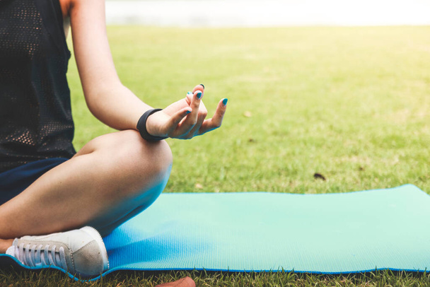 Woman Fitness Meisje zit en doet yoga in het park - Foto, afbeelding