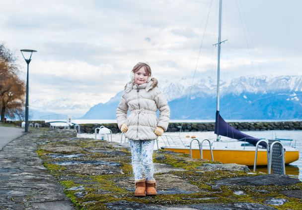 cute dziewczynka pozowanie na zewnątrz, stojąc nad jeziorem z góry - Zdjęcie, obraz