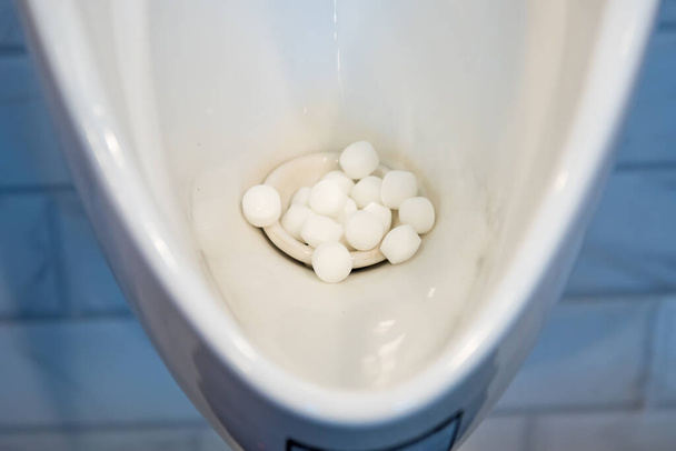 Urinals in de mannelijke toiletten met vuile ballen - Foto, afbeelding