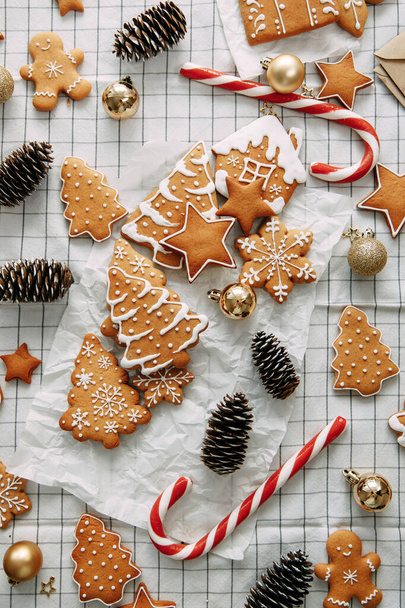 composition with ginger cookies and cones on a light background. christmas flatley layout with cookies and a christmas tree. - Foto, imagen