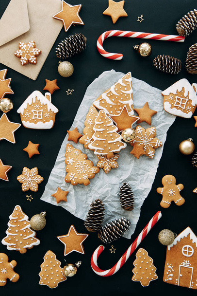 Composition with ginger cookies and cones on a dark background. christmas flatley layout with cookies and a christmas tree. - Foto, imagen