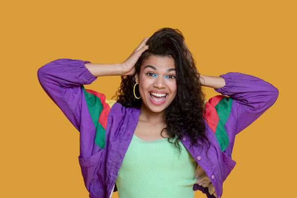 Cute dark-haired young girl in bright jacket looking cheerful - Fotó, kép