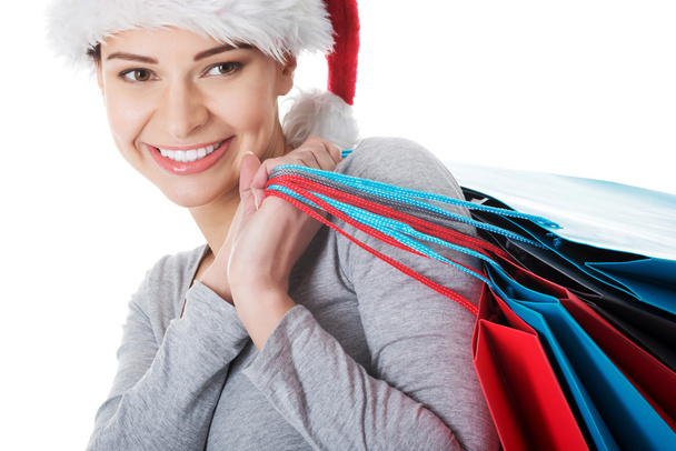 Woman in santa hat with shopping bags. - Fotó, kép