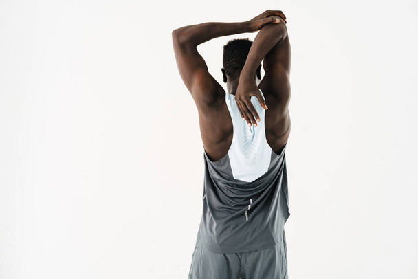 Young african american sportsman doing exercise while working out isolated over white background - Photo, Image