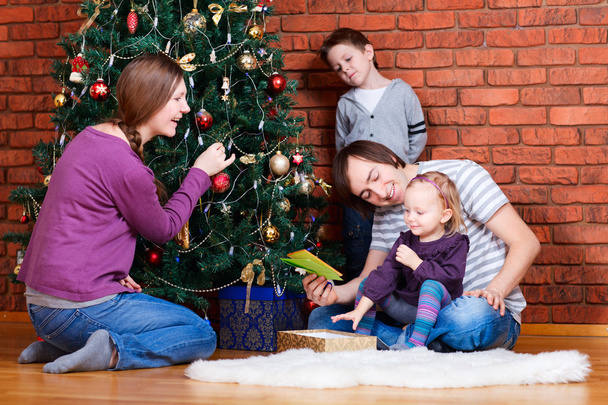 Family decorating Christmas tree - Фото, зображення