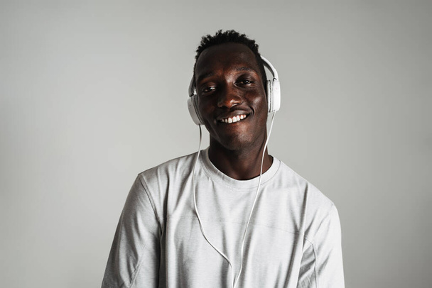 Happy african american guy listening music with headphones and smiling isolated over white background - Foto, immagini