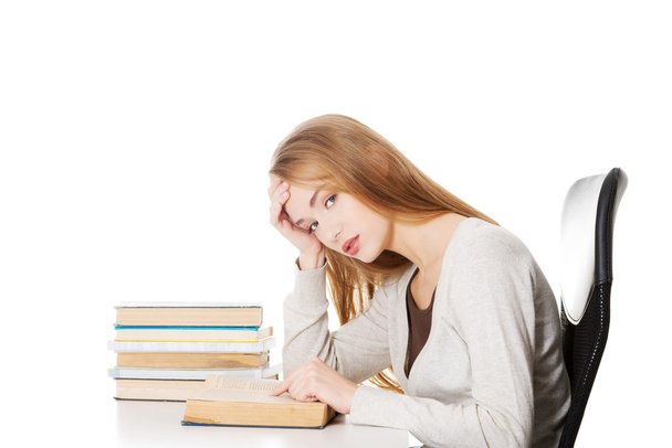 Student woman sitting by stack of books - Foto, immagini