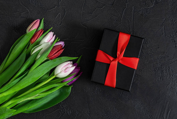 Šťastný Valentýn, Den žen, koncept na Den matek. Dárek box a tulipány květiny na černém pozadí, kopírovat prostor pro váš text. - Fotografie, Obrázek