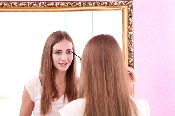 Young beautiful woman making make-up near mirror - Foto, immagini