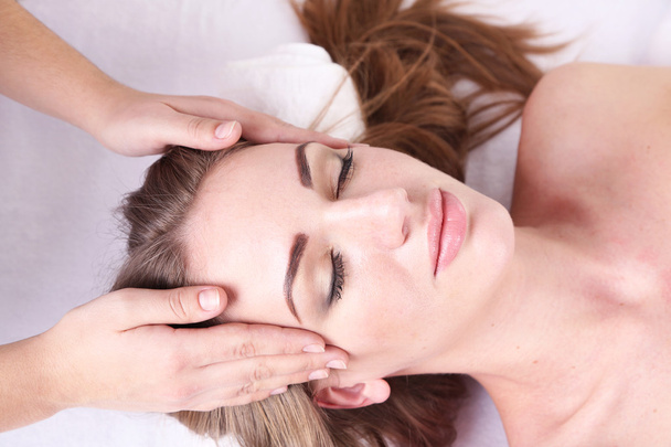 Beautiful young woman having head massage in spa salon - Foto, Imagem