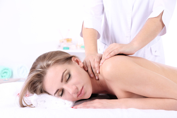 Beautiful young woman having back massage in spa salon - Photo, Image