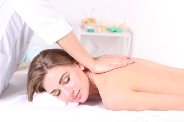Beautiful young woman having back massage in spa salon - Valokuva, kuva