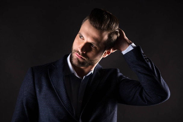 Close-up portrait of his he nice attractive content well-groomed guy agent broker employer partner leader touching hairdo corporate trend isolated on dark black color background - Foto, immagini
