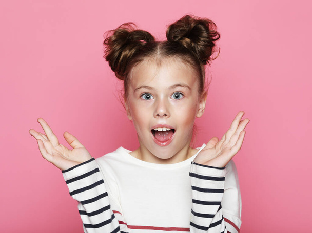 Portrait of cheerful surprised little girl on yellow background - Fotó, kép