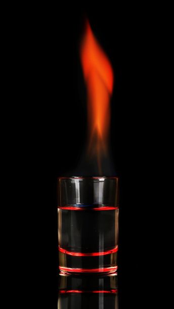 Glass with burning alcohol on black background - Photo, Image