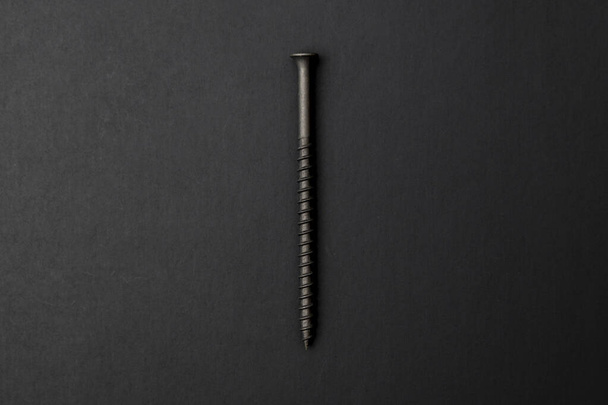 A top view of self-tapping screw on a black background - Foto, immagini
