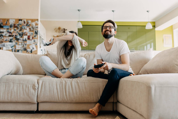 beautiful young couple playing video games together at home - Fotografie, Obrázek