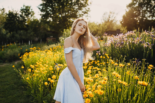 retrato de hermosa mujer joven en vestido de verano en pradera verde con flores amarillas - Foto, imagen
