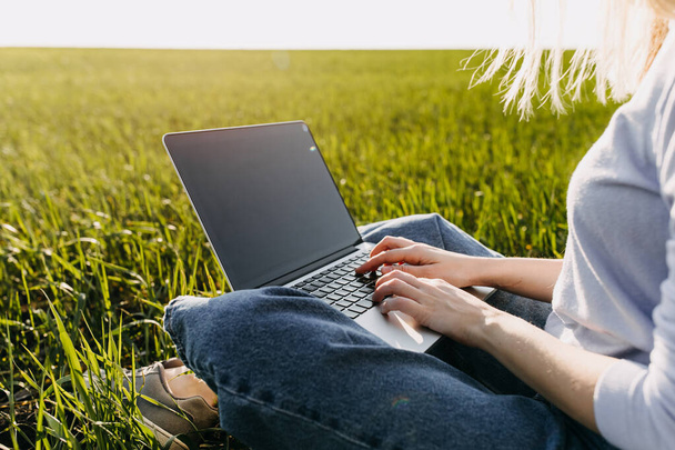 bela jovem mulher trabalhando com laptop no campo verde - Foto, Imagem