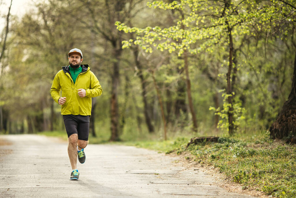 young man in sportswear running on nature - Photo, Image