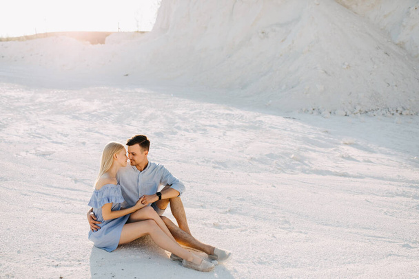 beautiful young couple sitting together in sand quarry - 写真・画像
