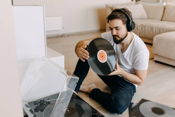 joven guapo escuchando discos de vinilo en casa - Foto, imagen