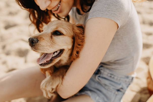 美しい若い女性とともに彼女のコッカー・スパニエル子犬一緒に公園で時間を過ごす - 写真・画像