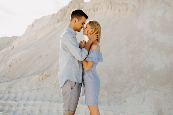 美しい若いカップルが砂の採石場で抱き合って - 写真・画像