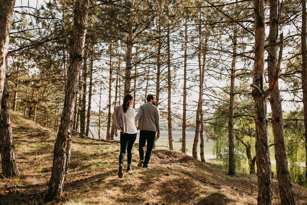 красива молода пара проводить час разом у красивому сосновому лісі
 - Фото, зображення