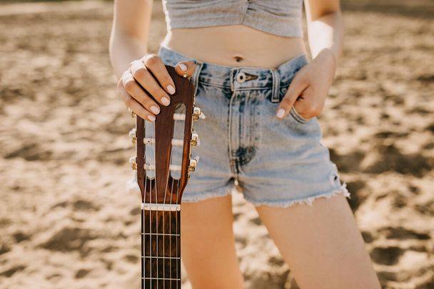 tiro recortado de mujer con guitarra acústica en la playa de arena - Foto, imagen