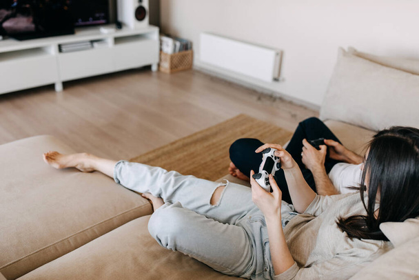 beautiful young couple playing video games together at home - Photo, image