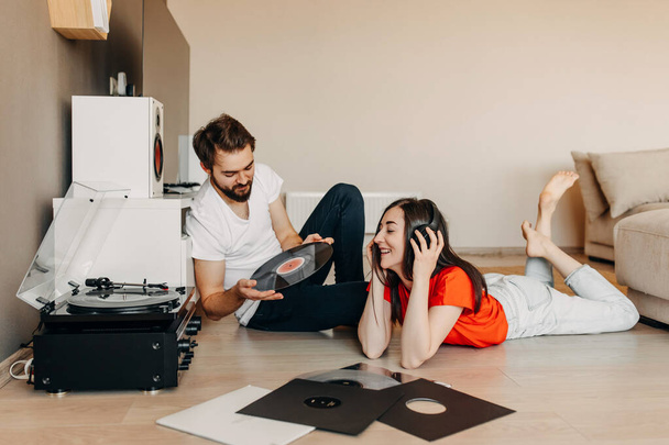 beautiful young couple listening vinyl records together at home - Φωτογραφία, εικόνα