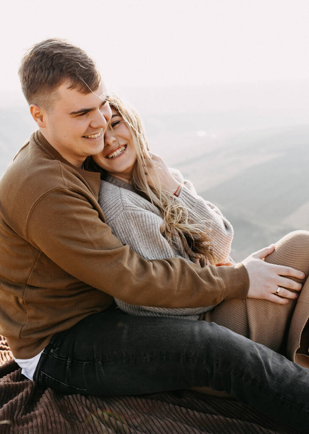 pareja joven enamorada sentada en la montaña - Foto, imagen