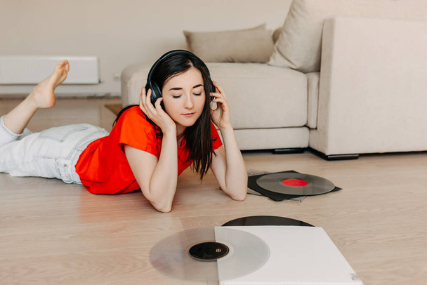 beautiful young woman listening vinyl records at home - Foto, Bild