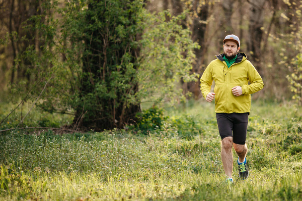 young man in sportswear running on nature - Foto, afbeelding