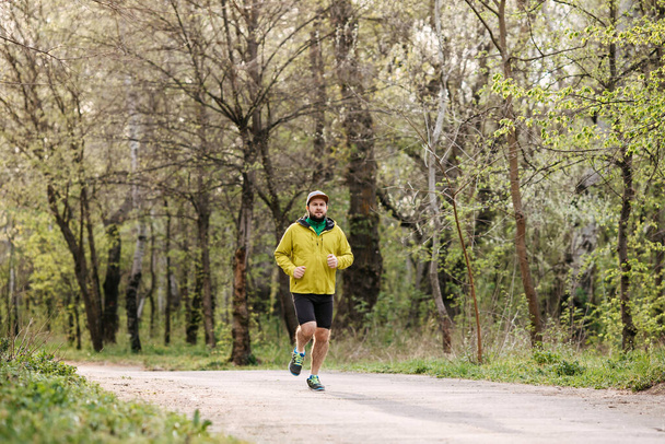 young man in sportswear running on nature - Fotó, kép