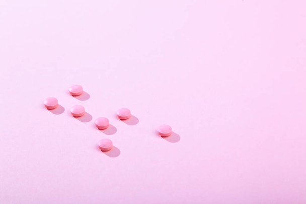 Compresse e pillole, vitamine e antibiotici su sfondo rosa, spazio copia - Foto, immagini