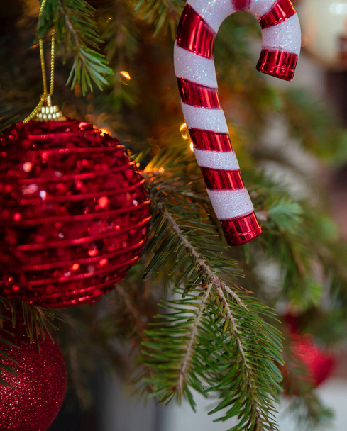 Christmas tree, burning fireplace background. Warm cozy Xmas holiday home. Christmas bauble closeup, greeting card template - Zdjęcie, obraz