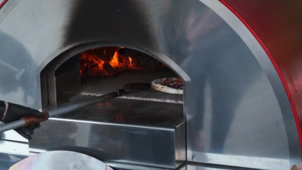 Crop kokki leivonta pizza kuumassa uunissa - Materiaali, video