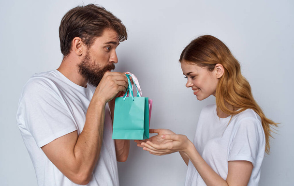 man and woman exchanging gifts holidays fun light background - Photo, Image