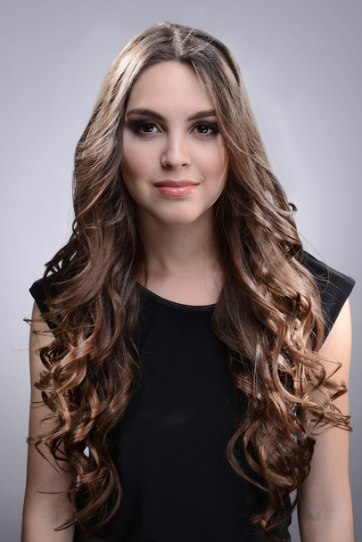Beautiful young woman with long hair on grey background - Zdjęcie, obraz