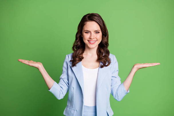 Photo of charming lady two hands hold empty space toothy smile wear blue jacket isolated green color background - Фото, зображення