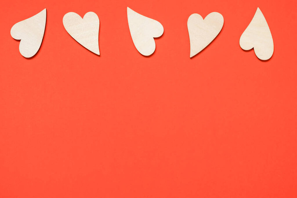 Valentine's day, love, romantic concept. Wooden hearts on a red background. Copy space. - 写真・画像
