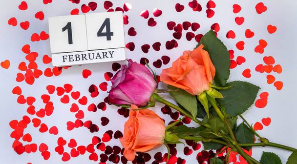 kytice květin posetá srdíčky a dřevěný kalendář s datem 14. února. Svatý Valentýn. - Fotografie, Obrázek