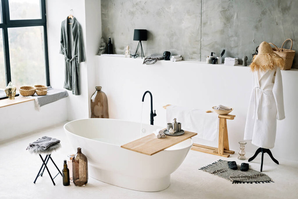 Біла сучасна ванна в сучасній квартирі зі стильним дизайном інтер'єру в стилі лофт, домашнім декором. М'який вибірковий фокус
. - Фото, зображення
