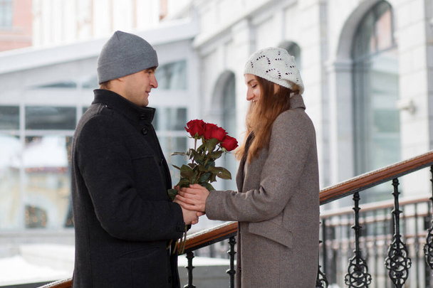 Young man gift his girlfriend bouquet of roses in the city - Foto, immagini