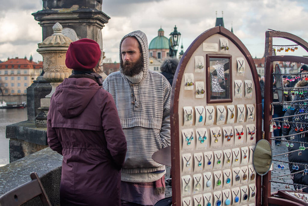 Prag, Tschechien. 01.11.2020. Touristen gehen auf der Karlsbrücke in der historischen Stadt spazieren. Obdachlose beginnen auf der Brücke. - Foto, Bild