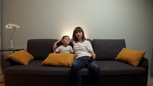 gelukkig familie - moeder met haar kleine zoon kijken tv - Video
